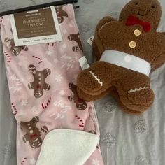 a brown teddy bear laying on top of a bed next to a pink and white blanket