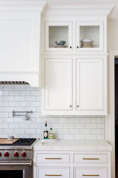 a kitchen with white cabinets and an oven