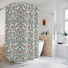 a bathroom with a bathtub, sink and shower curtain that has flowers on it