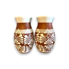 two brown and white vases sitting next to each other