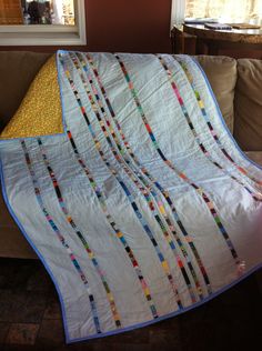 a large white quilt sitting on top of a couch