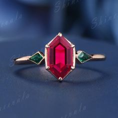 a close up of a ring with a red and green stone on it's side