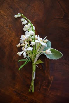 a bouquet of white flowers sitting on top of a wooden table