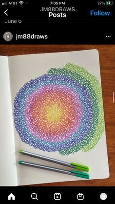 two pens are sitting on top of a notebook with an intricately designed circle in the middle