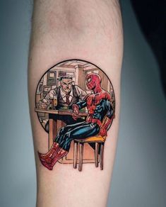 a man with a spider - man tattoo on his arm sitting in front of a bar