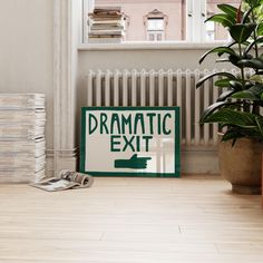 a green and white sign sitting on top of a wooden floor next to a potted plant