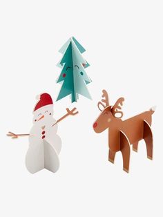 two paper cut out animals standing next to each other in front of a christmas tree