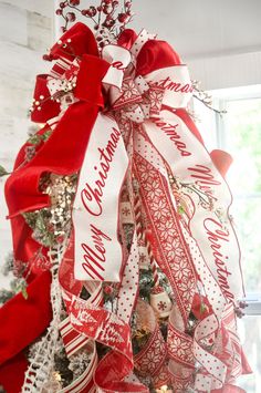 a christmas tree decorated with red and white ribbons