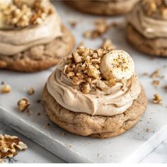 some cookies with frosting and nuts on top