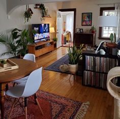 a living room filled with furniture and a flat screen tv on top of a wooden table