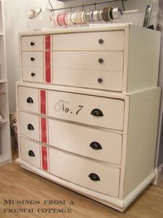 a white dresser with red stripes on it