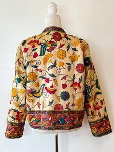 This traditional cotton jacket is refined, classic yet colorful. Incorporates a multitude of colors that will compliment your existing wardrobe. Fully embroidered on all sides, mixed colors which may be worn in all seasons. Embroidery is subtle, without embellishments, 3/4 sleeves, fully lined, open duster style. Made of cotton with unique stylish embroidery and printing. A unique combination of colorful embroidery in a floral and bird pattern. Impressive enginnered border running the front panels, tab neck, and sleeves.Designed to be worn open, easy fit. On trend, versatile and comfortable. It Is perfect for any event and great for travel. The traditional embroidery patterns are perfect for the boho look of the season. Consider purchasing for a special gift; wedding, anniversary, holiday, Traditional Embroidered Outerwear For Fall, Traditional Embroidered Fall Outerwear, Traditional Nehru Jacket With Multicolor Embroidery For Spring, Traditional Embroidered Border Outerwear For Fall, Traditional Outerwear With Embroidered Border For Fall, Bohemian Nehru Jacket With Intricate Embroidery For Fall, Festive Cotton Outerwear With Intricate Embroidery, Festive Cotton Outerwear With Floral Embroidery, Folk Style Floral Embroidered Outerwear For Festivals