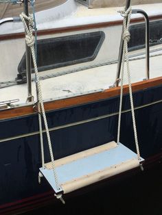 a blue and white boat with ropes hanging from it's sides