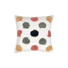 a white pillow with multicolored circles on the front and back, sitting on a white surface