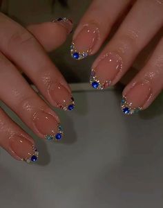 a woman's hands with blue and gold nail polish