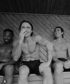 three men sitting in a sauna with one holding his face to his mouth and the other looking up