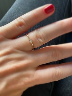 a woman's hand with a red manicure and a diamond ring on it