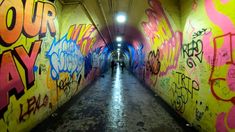 a tunnel with graffiti all over the walls