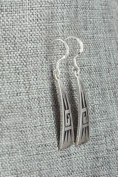 These sterling silver earrings were made by Hopi silversmith Augustine Mowa. The back is stamped sterling.Length: 1 1/2"Width: 3/8"Free shipping on all orders! We ship with USPS and always include tracking. All orders ship within a day of payment.Returns are accepted up to 30 days after you receive your order. Just send us a message. Our shop offers cash back or store credit. The item must be returned in new condition. Handmade Southwestern Silver Earrings, Symbolic Sterling Silver Earrings With Oxidized Finish, Southwestern Green Sterling Silver Earrings, Southwestern Hand-strung Sterling Silver Jewelry, Silver Casting, Southwestern Sterling Silver Hand-strung Jewelry, Native American Jewelry, Free Jewelry, Sterling Silver Earrings