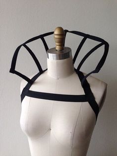 a white mannequin with black straps on it