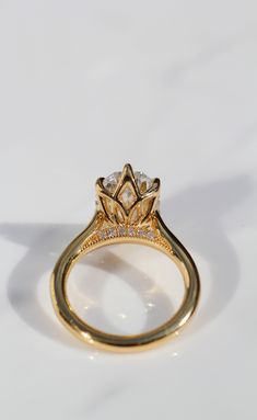 a yellow gold engagement ring with diamonds on it