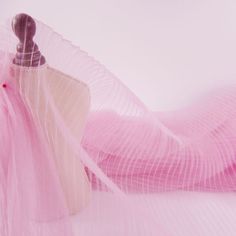 a dress hanging on a mannequin's dummy with pink fabric around it