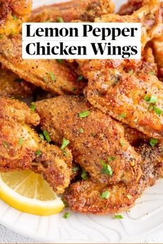 chicken wings with lemon wedges and parsley on a white plate, ready to be eaten