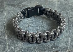 Grey paracord adventure bracelet with buckle clasp Robust and stylish, perfect for your next adventure -High quality, durable paracord  -Plastic buckle clasp -Bracelet width: 1cm -Available in five different lengths -Perfect gift for all outdoor enthusiasts and those looking for a stylish accessory  How to measure your wrist... 1.Wrap a strip of paper or string around the smallest part of your wrist. 2.Measure the bit of string or paper flat against a ruler from the end to the bit that when on y Bracelet Clasps, Braided Bracelets, Paracord, Stylish Accessories, Bracelet Sizes, Advent, Buckle, Braids, Jewelry Bracelets