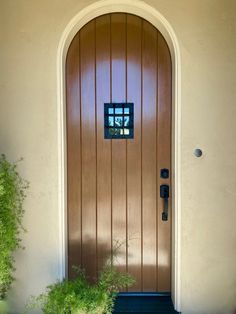 the front door to a house with potted plants