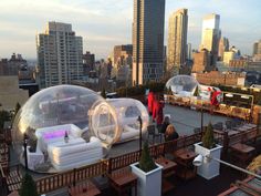 some people are standing on the roof of a building with giant inflatables