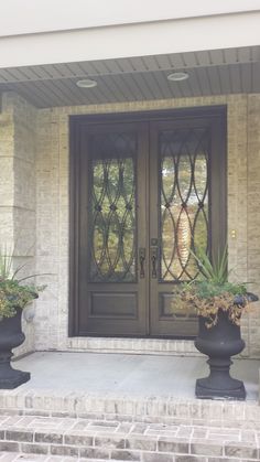 two large planters on the front steps of a house