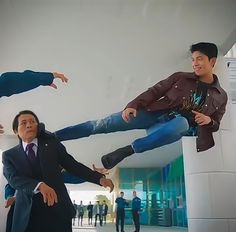 three men in suits and ties are posing for a photo with one man upside down