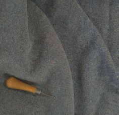 a wooden object laying on top of a gray cloth