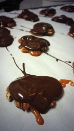 chocolate covered donuts with caramel drizzled on them sitting on a table