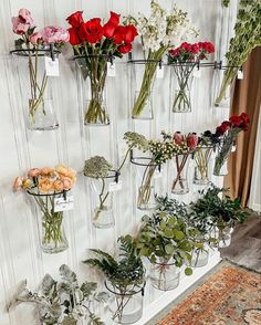 several vases filled with flowers on a wall