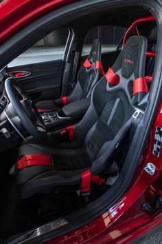 the interior of a red car with black seats