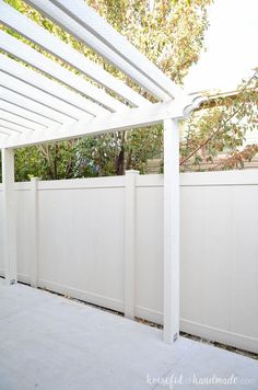 a cat sitting on top of a white fence