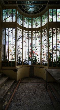 the inside of an old building with stained glass windows and floral designs on the walls