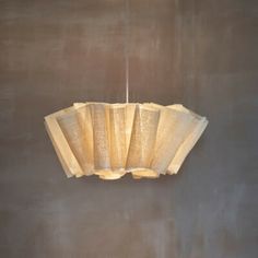 a light fixture hanging from the ceiling in a room with concrete walls and flooring