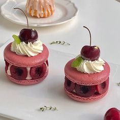 two desserts with cherries and whipped cream on them