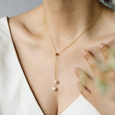 Embrace timeless elegance with our Two Oval Drop Pear Lariat Necklace. Crafted from high-quality brass, this 16-inch necklace features genuine 6mm freshwater pearls, providing a touch of sophistication to any outfit. Available in gold and silver, this minimalist, elegant, and unique design is perfect for layering or wearing alone. Product Specifications: Length: 16 inches Pearl Size: 6mm Material: Brass Color Options: Gold/Silver Design: Minimalist, Elegant, Unique Gift Attributes: Ideal for mot Elegant Lariat Jewelry For Wedding, Delicate Drop Lariat Necklace For Formal Occasions, Elegant Teardrop Pendant Lariat Necklace For Wedding, Elegant Drop Lariat Necklace For Anniversary, Wedding Pearl Chain Drop Necklace, Wedding Drop Necklace With Pearl Chain, Elegant Lariat Drop Necklace For Wedding, Elegant Teardrop Backdrop Necklace As Gift, Elegant Long Drop Backdrop Necklace As Gift