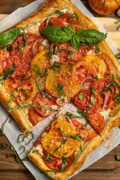 a square pizza with tomatoes and basil on top