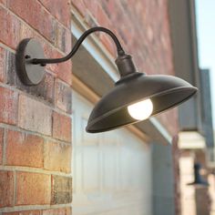 an outdoor light on the side of a brick building