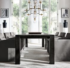 a living room filled with furniture and a chandelier hanging over a wooden table