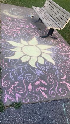 a bench sitting on top of a sidewalk covered in chalk