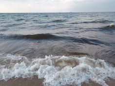 the water is choppy and foamy on the beach