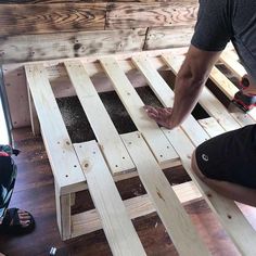 a man is sanding up some wooden pallets