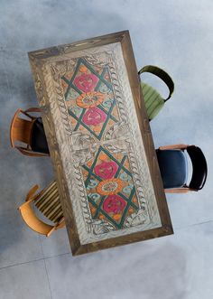 an overhead view of a table with chairs and a painting on the wall above it