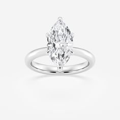 a white gold ring with an oval cut diamond in the center, set on a plain surface