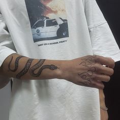 a person wearing a white shirt with tattoos on their arm